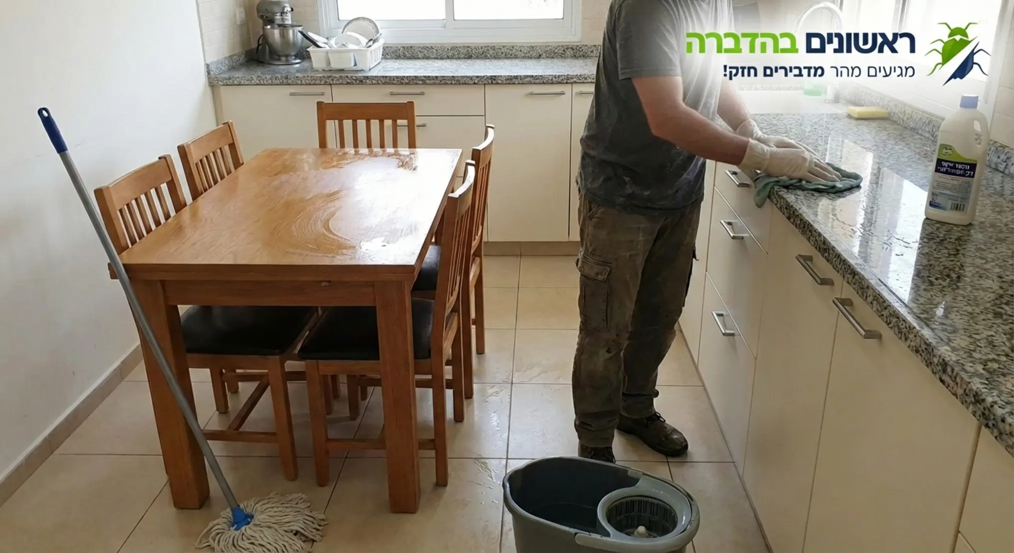 תמונה המראה אדם מנקה במטלית לחה שולחן אוכל ושיש במטבח, בעוד שרצפת הבית באזור הפאנלים נשארת יבשה לחלוטין וללא מגע של מים
